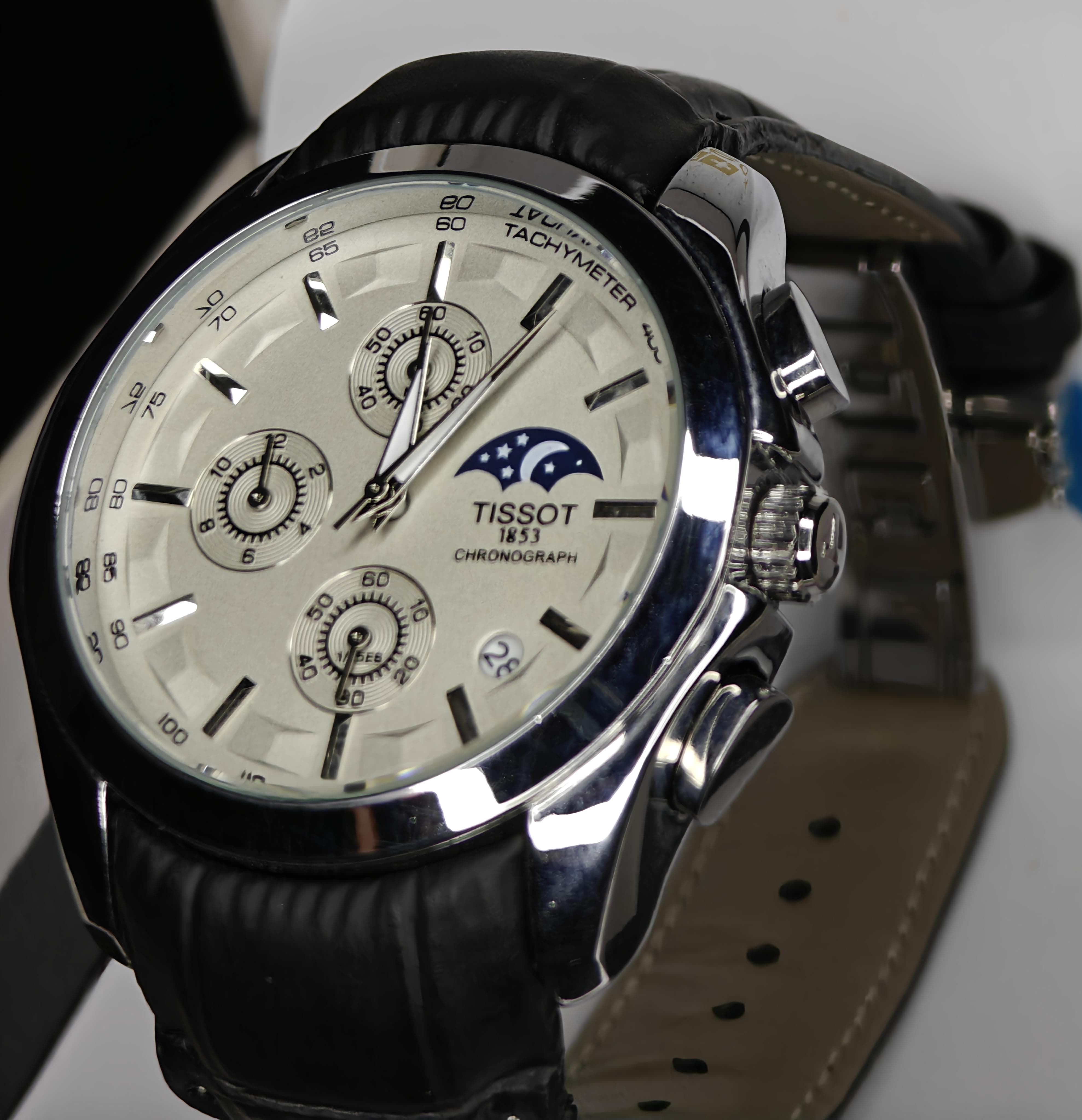 Tissot watch with black leather strap on a white background